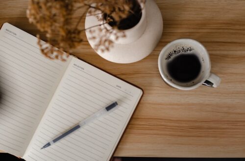 a cup of coffee and a notebook on a table